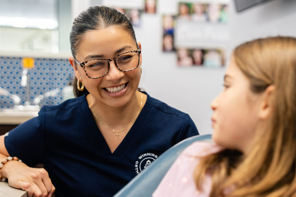 Team member with a young patient at her orthodontic visit