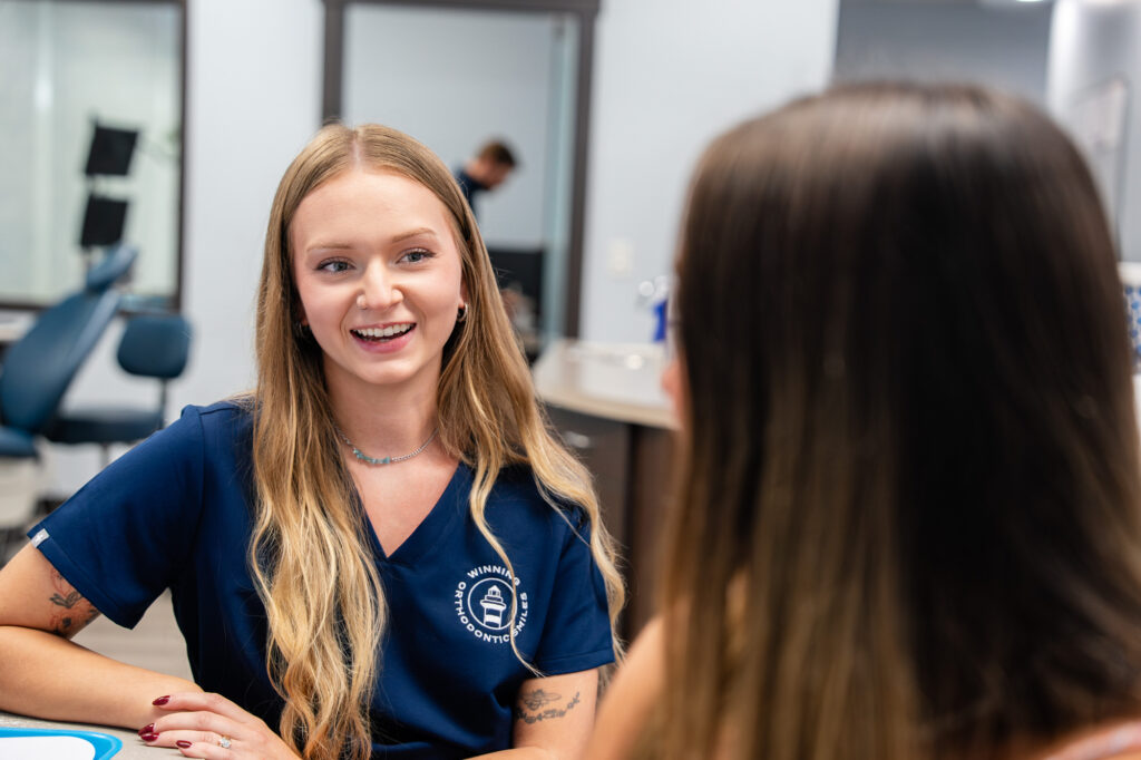 Winning Orthodontic Smiles team member talking with a patient