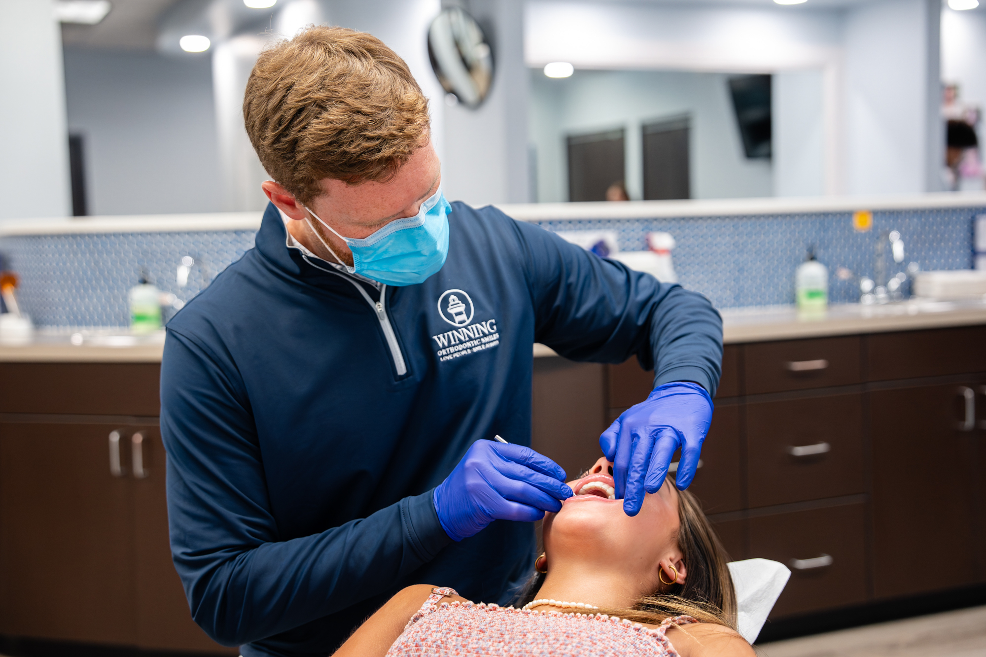 Orthodontist checking a patient's braces in the treatment chair