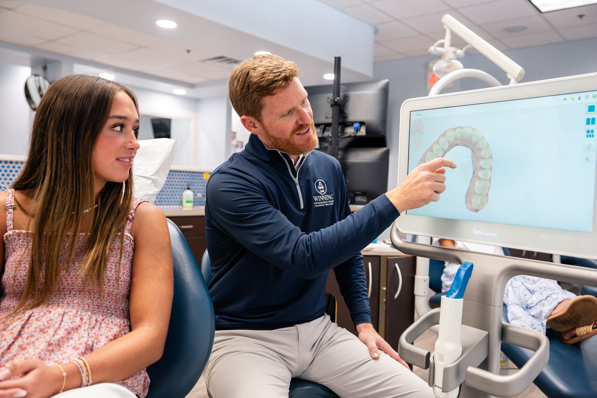 Orthodontist showing a teen patient her digital teeth scan on screen